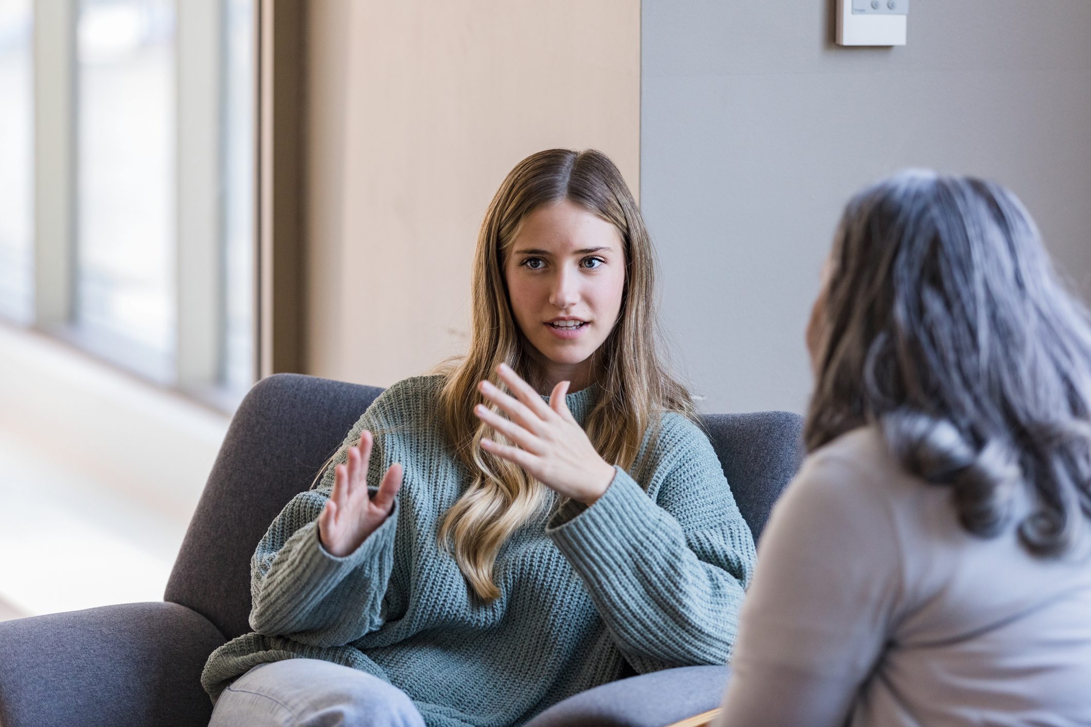 a girl talks to a therapist in her office