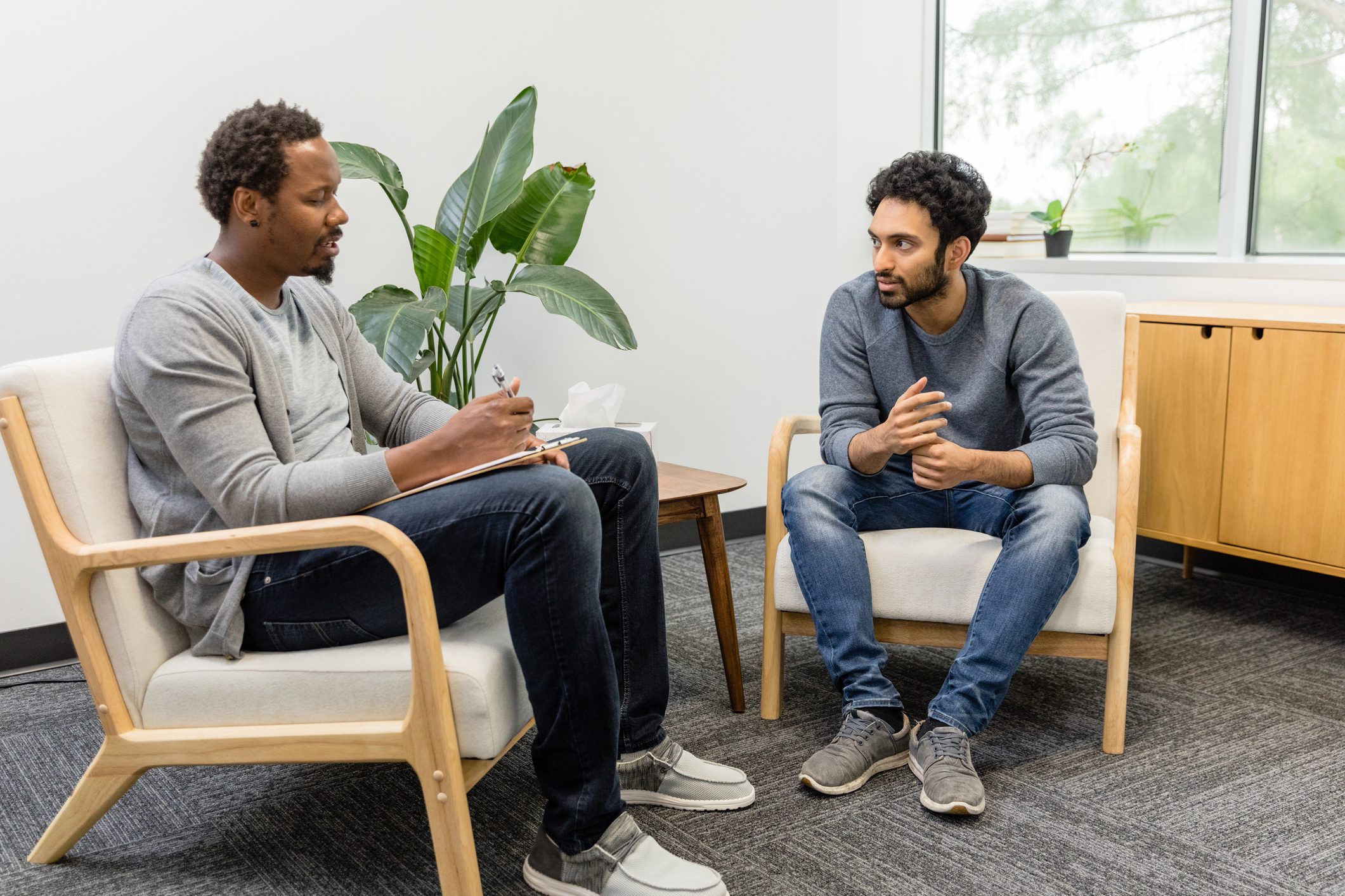 A man and his therapist discuss drug addiction in a therapy setting.